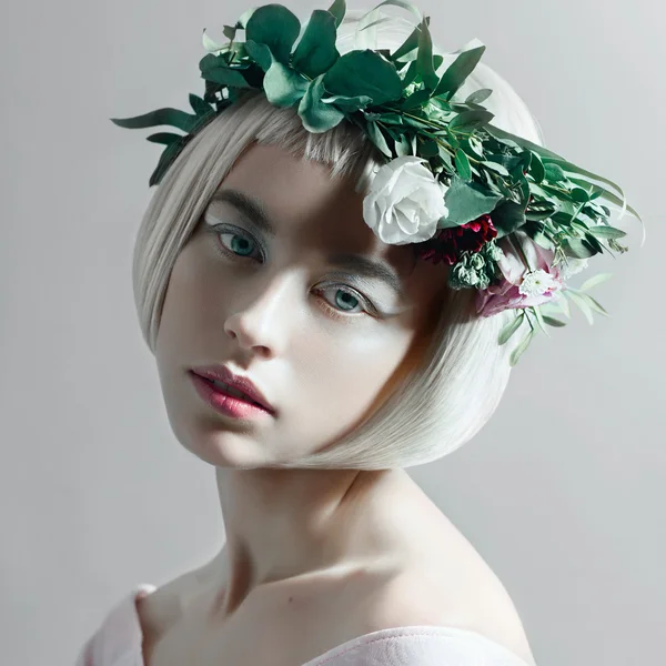 Vrouw met kort haar en een krans van bloemen — Stockfoto