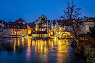Bamberg 'in aydınlatılmış tarihi binaları 30 Kasım 2025' te Almanya 'nın Franconia eyaletindeki Regnitz Nehri' ne yansıdı..