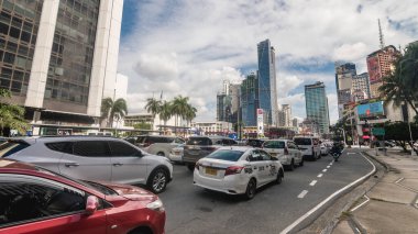 Makati, Metro Manila, Filipinler - Ekim 2020: Kuzey Makati 'de Century City görülebilen araçlar Makati Bulvarı boyunca kırmızı ışıkta duruyor.