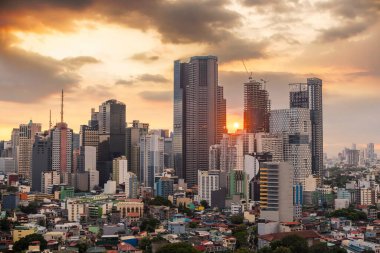 Makati, Metro Manila, Filipinler güneş Makati 'nin kuzey tarafındaki yüksek binalara karşı batar. Şehir manzarası görüntüsü.