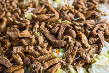 Pancit bihon 'un üstüne bol miktarda domuz eti. Yakın görünüm.