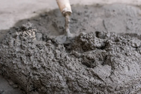 Küçük bir yığın ıslak beton ve kürek yakın çekim. Açık havada vurulmuş. Bir DIY projesi ya da onarım için. El emeği.