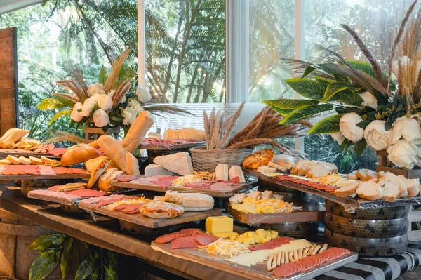 A Cheese & Charcuterie Grazing Table filled with assorted meats, cheeses and bread at an events place.