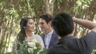 Tagaytay, Cavite, Filipinler- Bir fotoğrafçı, resepsiyon alanının dışında yeni evli bir çiftin fotoğraflarını çeker. Sahne arkasında çekim.