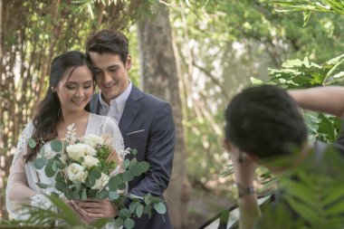 Tagaytay, Cavite, Filipinler- Bir fotoğrafçı, resepsiyon alanının dışında yeni evli bir çiftin fotoğraflarını çeker. Sahne arkasında çekim.