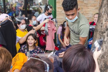 Divisoria, Manila, Filipinler. Bir sokak satıcısı müşterilerine yardım eder. Hepsi yüz maskesi takıyor ama sosyal mesafeyi zar zor takip ediyorlar..