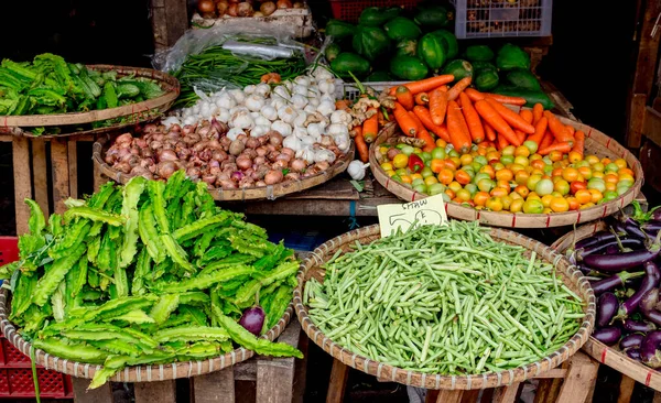 Filipin pazarında acı kabak, patlıcan, yeşil fasulye, domates, kanatlı fasulye, havuç, soğan ve sarımsak seçimi. Bazı sinekler sürüler halinde sebzelerin üzerine konarak sağlık sorunlarını gündeme getiriyor.