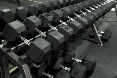 Spor salonunda ya da fitness kulübünde ağır bir büyü sehpası. Egzersiz ve piramit eğitimi ya da ciddi vücut geliştirme konsepti için rafları çalıştırmak.