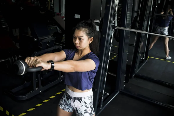 一位女运动员在体育馆里摇铃 锻炼的肩膀或交叉 间接射击 — 图库照片