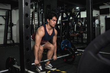 Genç bir adam halter kaldırma seti başlatmak üzere. Aynaya bakarken yüzünde ciddi bir ifade vardı..