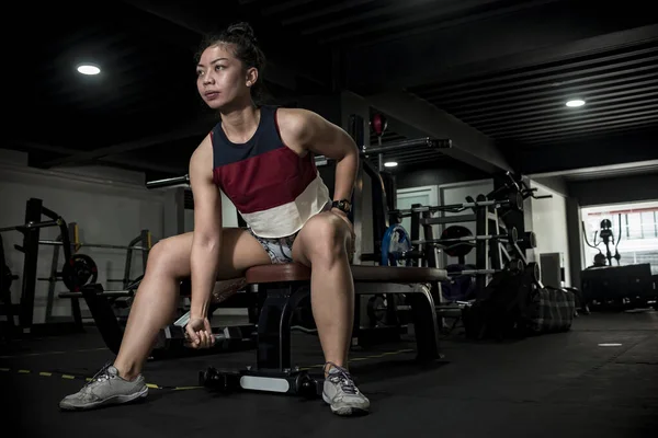 一位体格健康的亚洲运动员在做哑铃式的集中训练时 蜷曲在长椅上 在体育馆练二头肌 — 图库照片