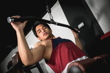 Genç Asyalı bir adam spor salonunda son çekimleri yapıyor. Sırt egzersizleri yapıyorum..