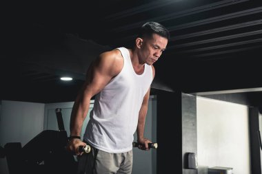 Fit bir Asyalı erkek sos istasyonunda triseps dalışı yapıyor. Spor salonunda kol ve kol çalışıyor..