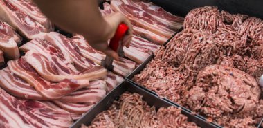 Çiğ domuz eti ya da liempo süpermarkette ya da et dükkanında sergileniyor. Fotoğrafta görünen bir çift maşa..