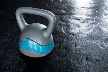 Spor salonunda lastik zeminde büyük plastik bir kettlebell. Sağ taraftaki boşluk.