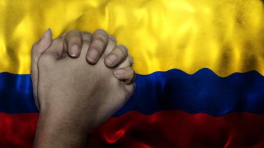 A hand praying with Flag of Colombia as background. Grunge, depressing look. Can represent adversity, crisis, Christian or Catholic prayer, forgiveness, worship or plea in country.