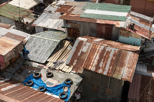 上图是用锈蚀的金属板和残余胶合板制成的墙壁和屋顶的贫民窟房屋 — 图库照片