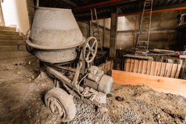 Bitmemiş bir ticari binanın zemin katında eski bir çimento karıştırıcısı duruyor..