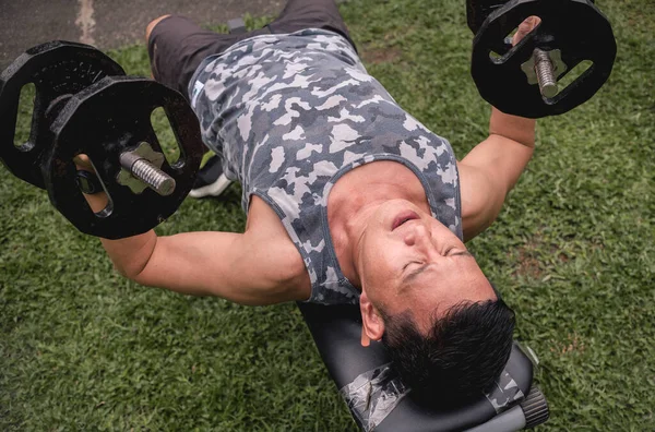 Middle Aged Asian Male Exercising Outdoors Doing Dumbbell Chest Flyes — Fotografia de Stock