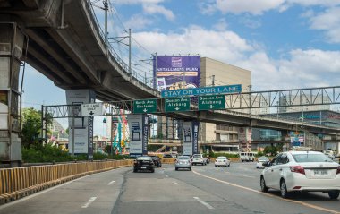 Quezon City, Metro Manila, Filipinler - Ocak 2021: EDSA 'nın güneye giden yolu. Sol tarafta MRT parmaklığı var. Sürücünün bakış açısı