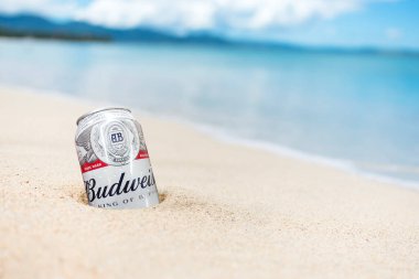 Filipinler - Ağustos 2020: Bir kutu Budweiser Birası kısmen tropikal bir plajda kumlara gömüldü.