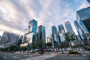 Bonifacio Global City, Taguig, Metro Manila BGC 'deki modern ofis gökdelenleri. Park alanının yakınındaki sokak manzarası. Öğleden sonra sahnesi.