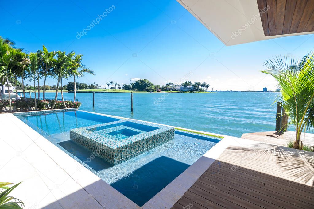 Miami Beach - Luxury infinity pool and jacuzzi by a waterfront. Contemporary South Florida design.