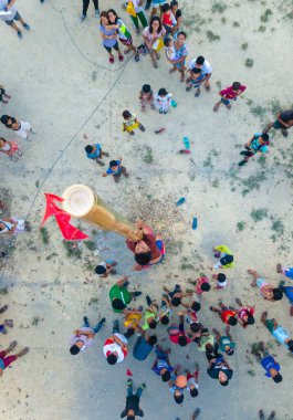 Tubigon, Bohol, Filipinler- bir çocuk kalabalığın gözü önünde kırmızı bayrağı yakalamak için yağlı bir bambu direğine tırmanmaya çalışıyor. Bu Palosebo olarak bilinen Filipin oyunudur..