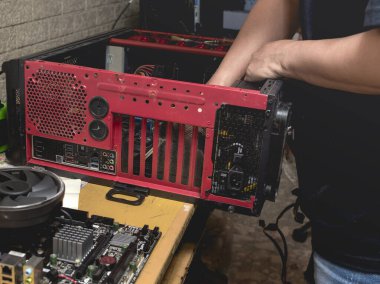 Bir bilgisayar teknisyeni ya da hobici kırmızı bir masaüstünü tamir eder, ana kartını çıkarır ve arızalar için sorun yaratır. Bir evde veya küçük bir ofiste..