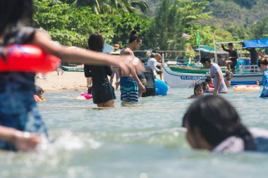 Calayo, Batangas, Filipinler - Yerel turistler hafta sonları sıcağı yenmek ve ailelerle bağ kurmak için plajı dolduruyorlar. Gevşek karantina kuralları.