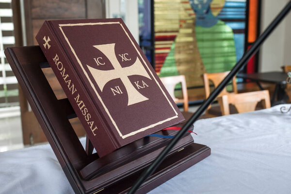 A closed Roman Missal on a stand of an altar of a prayer room or small chapel. A liturgical book of the Catholic church.