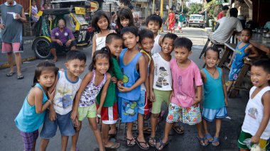 Manila, Filipinler gecekondu çocukları kameraya mutlu poz veriyor. Kötü koşullar altında mutluluk.