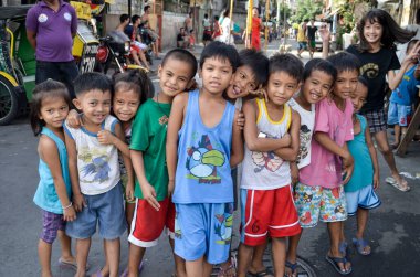 Manila, Filipinler gecekondu çocukları kameraya mutlu poz veriyor. Kötü koşullar altında mutluluk.