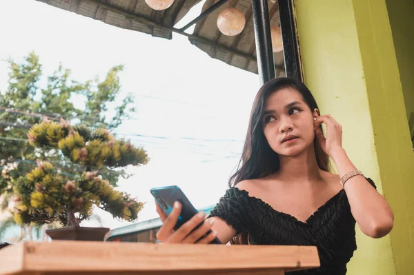Una Adolescente Asiática Pone Unos Auriculares Bluetooth Para Escuchar Música — Foto de Stock
