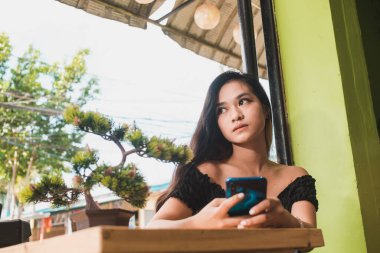 Genç Asyalı bir genç, Al Fresko Cafe 'de takılırken sosyal medyadaki bir sohbete cevap vermeye karar verir..