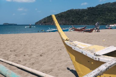 Eski, ahşap bir banka ya da sahibinin kumda sürüklediği sürgülü bir tekne. Calayo sahilinde, Nasugbu, Batangas.