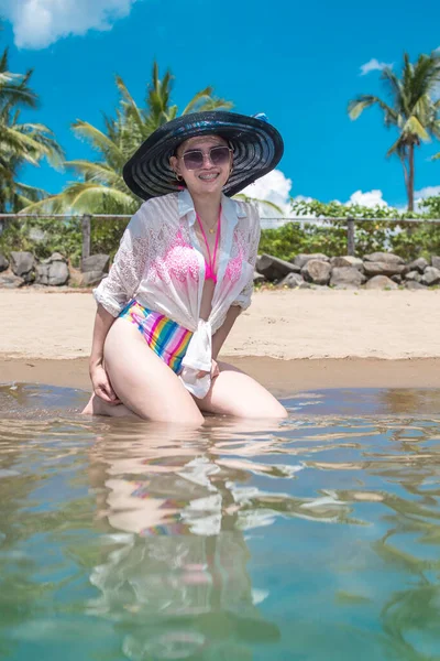 Uma Mulher Óculos Sol Fato Banho Colorido Chapéu Praia Desfrutam — Fotografia de Stock
