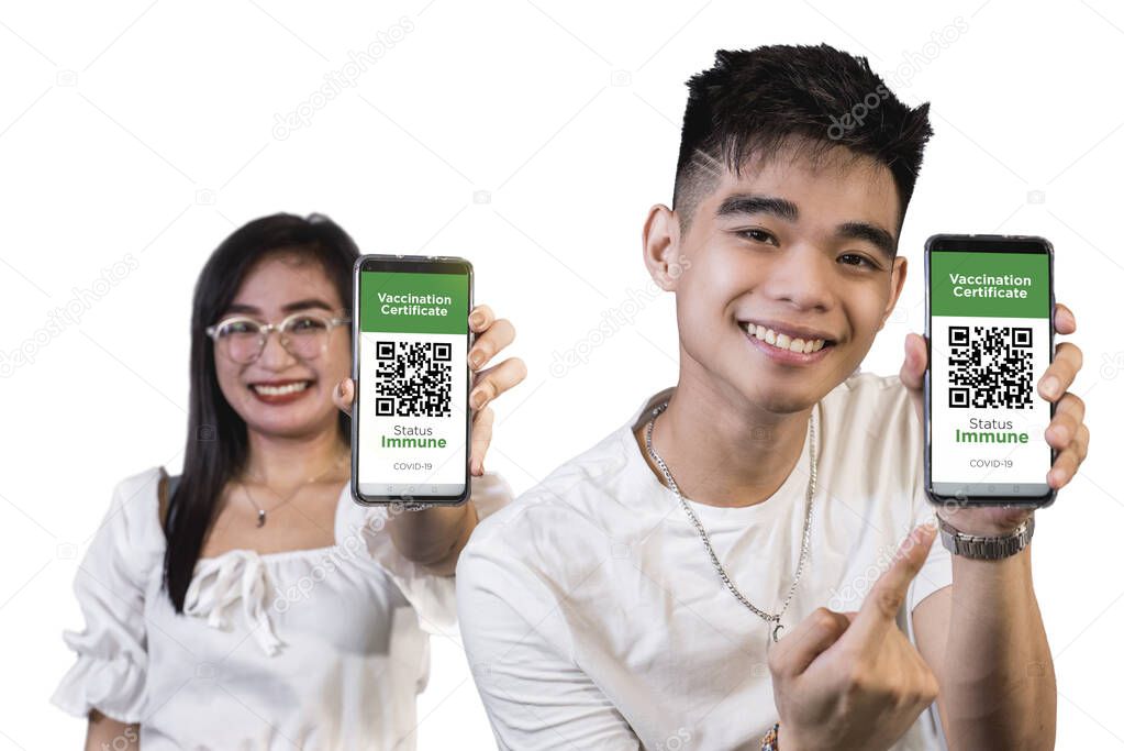 Two young asians presents their digital immunity passport or proof of vaccination as an app on their phone. Plain white background. Focused on phone.