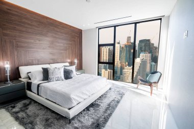 Beyaz tavanlı modern ve lüks bir yatak odası ve Bangkok silueti manzaralı ahşap aksanlı. Daire ya da Otel konaklama.