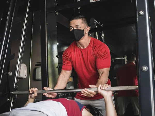 Treinador Ginástica Usando Uma Máscara Facial Avista Seu Cliente Fazendo — Fotografia de Stock