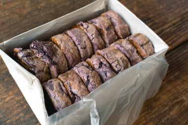 Tahta bir masaya yerleştirilmiş, Hopia ya da Bakpia aromalı lezzetli bir kutu. Fasulye dolu ay pastası gibi bir pasta.