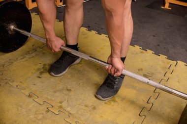 Alternatif bir kavrama ile halter kaldırma işlemi. Kirli bir kauçuk zeminde. Sıkı spor salonu ayarları.