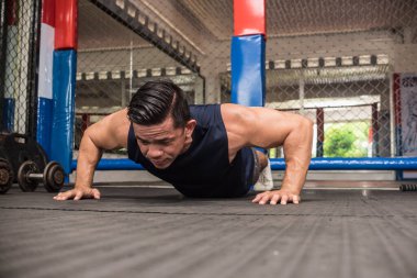 Formda bir Asyalı, MMA spor salonunda barfiks çeker. Vücut ağırlığı omuz egzersizi ya da HIIT egzersizi.