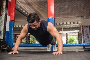 Formda bir Asyalı, MMA spor salonunda barfiks çeker. Vücut ağırlığı omuz egzersizi ya da HIIT egzersizi.
