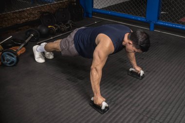 Atletik bir adam kauçuklu zeminde şınav çeker. MMA spor salonunda HIIT ya da jimnastik.