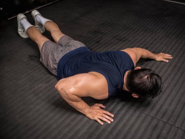 Formda ve atletik bir Asyalı spor salonunda şınav çekiyor. HIIT ya da jimnastik