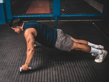 Atletik bir adam kauçuklu zeminde şınav çeker. MMA spor salonunda HIIT ya da jimnastik.