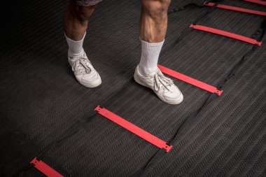 Çeviklik merdiveninde ayak hakimiyeti. Bir adım meydanın içinde. Fitness, kardiyo ve yoğun spor eğitimi konsepti.