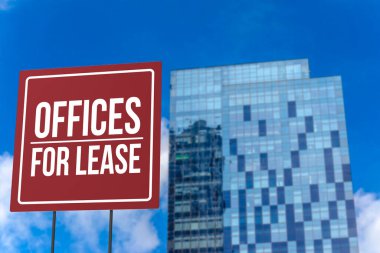 An offices for lease sign in front of a modern glassy commercial Grade A building. clipart