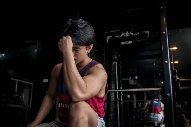 Yorgun ve depresif bir genç adam spor salonunda çalışmak için motive olmaya çalışır..